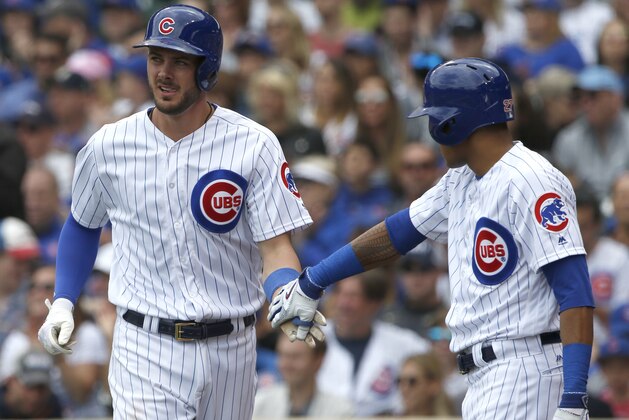 Chicago Cubs' Kris Bryant, left, celebrates with Addison Russell after scoring on a sacrifice fly by Willson Contreras in the first inning of a baseball game against the Milwaukee Brewers in Chicago, Sunday, May 21, 2017. (AP Photo/Nam Y. Huh)