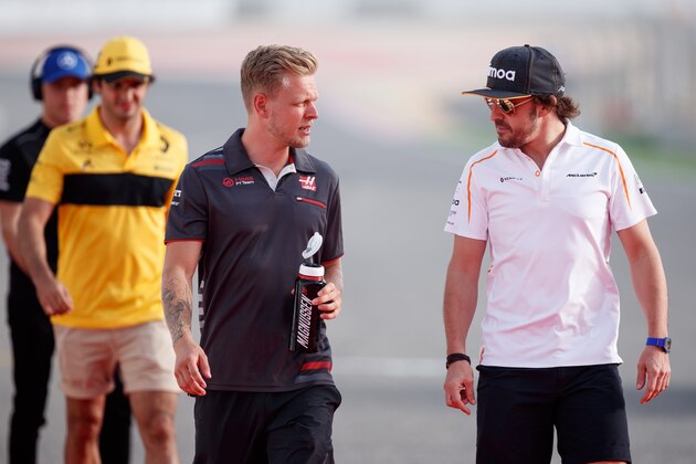 BAHRAIN, BAHRAIN - APRIL 08: Kevin Magnussen of Denmark and Haas F1 talks with Fernando Alonso of Spain and McLaren F1 on the drivers parade before during the Bahrain Formula One Grand Prix at Bahrain International Circuit on April 8, 2018 in Bahrain, Bahrain.  (Photo by Lars Baron/Getty Images)