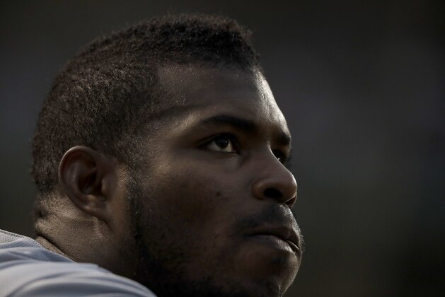 Los Angeles Dodgers' Yasiel Puig looks out over the field from the dugout during the third inning of a baseball game against the Chicago Cubs Tuesday, June 19, 2018, in Chicago. (AP Photo/Charles Rex Arbogast)