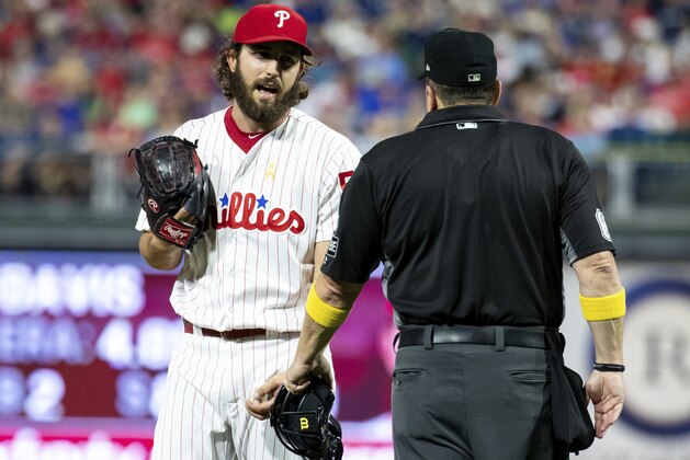Philadelphia Phillies relief pitcher Austin Davis, left, talks with umpire Marty Foster, right, during the eighth inning of a baseball game against the Chicago Cubs, Saturday, Sept. 1, 2018, in Philadelphia. Umpire Joe West confiscated a card from Davis in the eighth inning of Philadelphia's 7-1 loss. Davis and Phillies manager Gabe Kapler said he was using the card merely for information on the Cubs hitters. But West said it was illegal under Rule 6.02(c)(7), which states that the pitcher shall not have on his person, or in his possession, any foreign substance. (AP Photo/Chris Szagola)