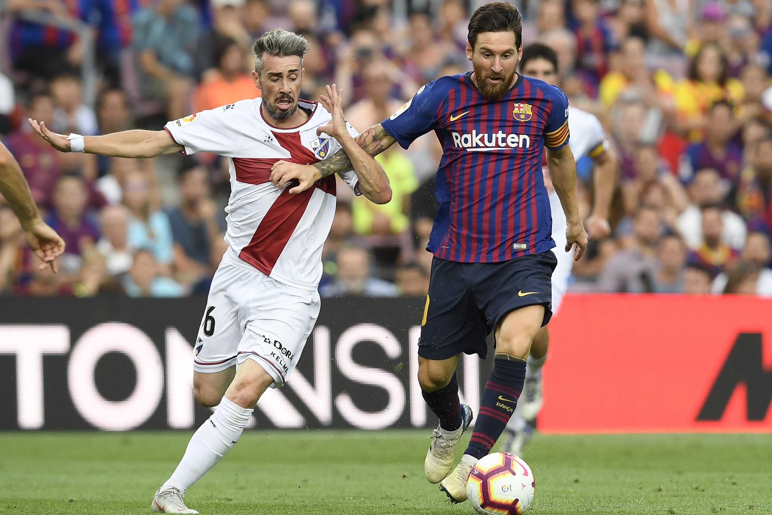 Barcelona's Argentinian forward Lionel Messi vies with SD Huesca's Portuguese defender Luisinho during the Spanish league football match between FC Barcelona and SD Huesca at the Camp Nou stadium in Barcelona on September 2, 2018. (Photo by LLUIS GENE / AFP)        (Photo credit should read LLUIS GENE/AFP/Getty Images)
