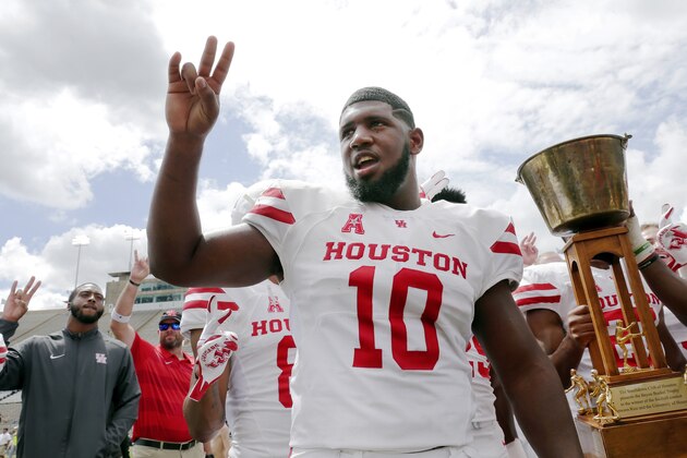 Houston Cougars defensive tackle Ed Oliver does the Cougar Paw with his teammates and the Bayou Bucket trophy after defeating Rice in a NCAA college football game Saturday, Sept. 1, 2018, in Houston. (AP Photo/Michael Wyke)