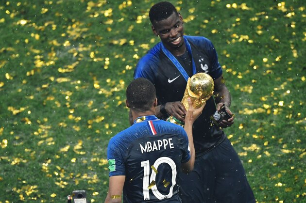 France's forward Kylian Mbappe (L) gives the trophy to France's midfielder Paul Pogba (R) as they celebrate during the trophy ceremony after winning the Russia 2018 World Cup final football match between France and Croatia at the Luzhniki Stadium in Moscow on July 15, 2018. (Photo by GABRIEL BOUYS / AFP) / RESTRICTED TO EDITORIAL USE - NO MOBILE PUSH ALERTS/DOWNLOADS        (Photo credit should read GABRIEL BOUYS/AFP/Getty Images)
