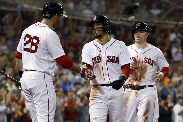 Boston Red Sox's Mookie Betts smiles as he is greeted by J.D. Martinez after scoring from first on a three-run double by Andrew Benintendi during the fourth inning of a baseball game against the Cleveland Indians on Wednesday, Aug. 22, 2018, in Boston. (AP Photo/Winslow Townson)