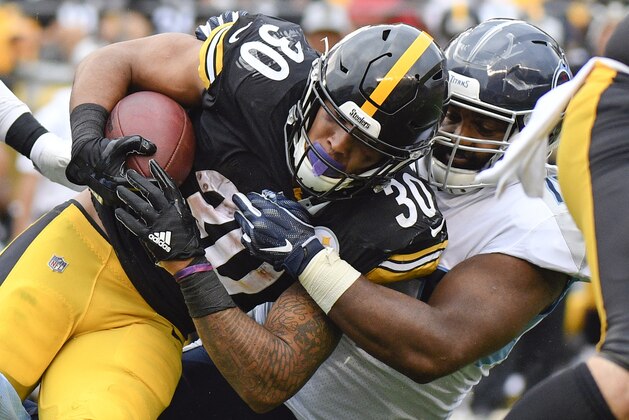 Pittsburgh Steelers running back James Conner (30) is hit by Tennessee Titans defensive end Julius Warmsley in the first half of an NFL preseason football game, Saturday, Aug. 25, 2018, in Pittsburgh. (AP Photo/Don Wright)