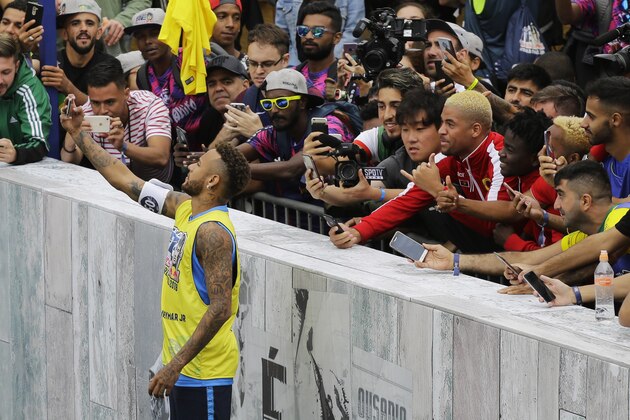 Brazilian soccer player Neymar takes a selfie backdropped by spectators at the Neymar Jr's Five youth soccer tournament in Praia Grande, Brazil, Saturday, July 21, 2018. (AP Photo/Nelson Antoine)