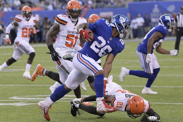 New York Giants running back Saquon Barkley (26) rushes past Cleveland Browns' Denzel Ward (21) during the first half of a preseason NFL football game Thursday, Aug. 9, 2018, in East Rutherford, N.J. (AP Photo/Bill Kostroun)