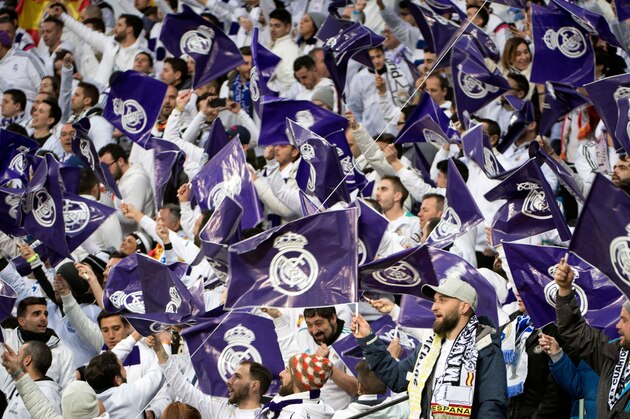 Real Madrid fans wave flags before the UEFA Champions League quarter-final second leg football match between Real Madrid CF and Juventus FC at the Santiago Bernabeu stadium in Madrid on April 11, 2018. / AFP PHOTO / CURTO DE LA TORRE        (Photo credit should read CURTO DE LA TORRE/AFP/Getty Images)