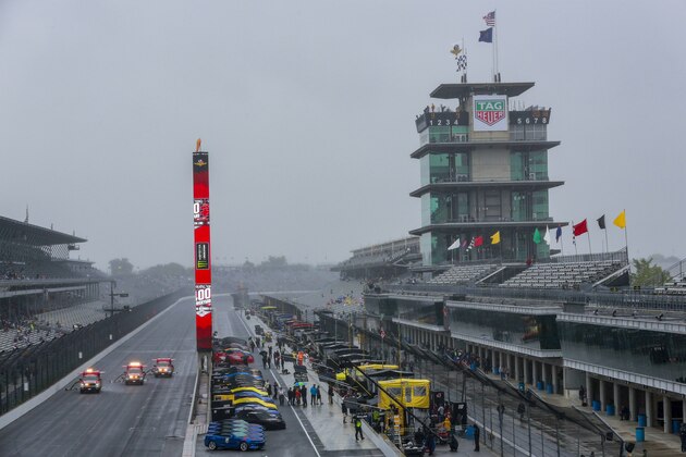 Trucks try to dry the track during a rain delay before a NASCAR Brickyard 400 auto race at Indianapolis Motor Speedway in Indianapolis, Sunday, Sept. 9, 2018. The race was postponed until Monday, Sept. 10. (AP Photo/R Brent Smith)