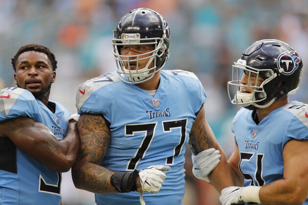 Tennessee Titans offensive tackle Taylor Lewan (77) is held back by defensive back Kevin Byard (31) and linebacker Will Compton (51), during a scuffle in the second half of an NFL football game against the Miami Dolphins, Sunday, Sept. 9, 2018, in Miami Gardens, Fla. (AP Photo/Brynn Anderson)