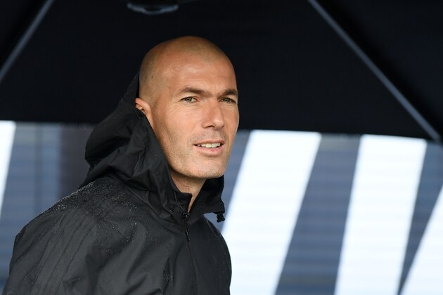 Former French football player and former Real Madrid coach Zinedine Zidane looks on as he shelters under an umbrella in Saint Denis, suburban Paris on June 11, 2018 during an event marking the 20th anniversary of France's 1998 World Cup victory. (Photo by Eric FEFERBERG / AFP)        (Photo credit should read ERIC FEFERBERG/AFP/Getty Images)