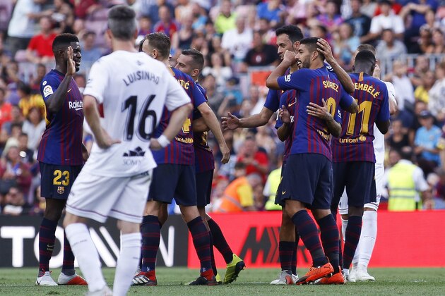 Barcelona's Luis Suarez, second right, celebrates scoring his side's third goal after the review of the VAR during a Spanish La Liga soccer match between Barcelona and Huesca at the Camp Nou stadium in Barcelona, Spain, Sunday Sept. 2, 2018. (AP Photo/Eric Alonso)
