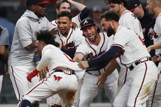 Atlanta Braves second baseman Ozzie Albies (1) is mobbed by his teammates after hitting a walk-off home run in the 11th inning of a baseball game against the Cincinnati Reds, Tuesday, June 26, 2018, in Atlanta. (AP photo/John Bazemore)