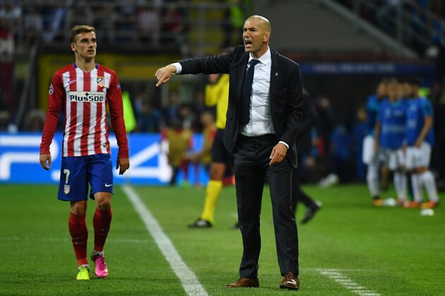 Real Madrid's French coach Zinedine Zidane (R) gives instructions to his players next to Atletico Madrid's French forward Antoine Griezmann during the UEFA Champions League final football match between Real Madrid and Atletico Madrid at San Siro Stadium in Milan, on May 28, 2016. / AFP / GERARD JULIEN        (Photo credit should read GERARD JULIEN/AFP/Getty Images)