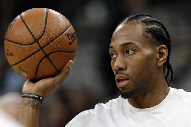 FILE - In this Jan. 5, 2018, file photo, San Antonio Spurs forward Kawhi Leonard handles a ball before an NBA basketball game against the Phoenix Suns in San Antonio. Two people familiar with the situation say San Antonio and Toronto have reached an agreement in principle on a trade that will send Kawhi Leonard to the Raptors and DeMar DeRozan to the Spurs. One of the people says the Spurs also are sending Danny Green to the Raptors as part of the deal. Both people spoke to The Associated Press on condition of anonymity Wednesday, July 18, 2018, because the deal has not been finalized. (AP Photo/Eric Gay, File)