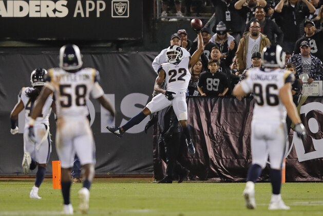 Los Angeles Rams cornerback Marcus Peters (22) celebrates in the end zone after making a 50-yard interception for a touchdown during the second half of an NFL football game against the Oakland Raiders in Oakland, Calif., Monday, Sept. 10, 2018. Los Angeles won the game 33-13. Looking on are the Rams' Cory Littleton (58) and Matt Longacre (96). (AP Photo/John Hefti)
