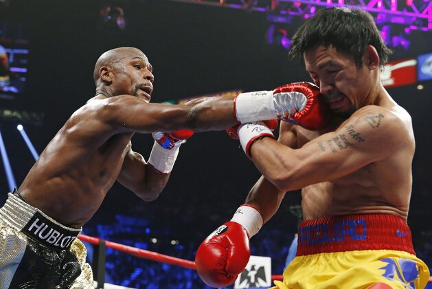 FOR USE AS DESIRED, YEAR END PHOTOS - FILE - Floyd Mayweather Jr., left, connects with a right to the head of Manny Pacquiao, from the Philippines, during their welterweight title fight on Saturday, May 2, 2015 in Las Vegas. (AP Photo/John Locher, File)