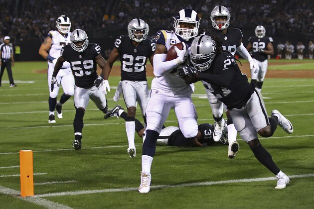 Los Angeles Rams running back Todd Gurley carries the ball over the goal line for a touchdown as Oakland Raiders defensive back Reggie Nelson hangs on during the first half of an NFL football game in Oakland, Calif., Monday, Sept. 10, 2018. In the background is Oakland Raiders linebacker Tahir Whitehead (59) and defensive back Rashaan Melvin (22). (AP Photo/Ben Margot)