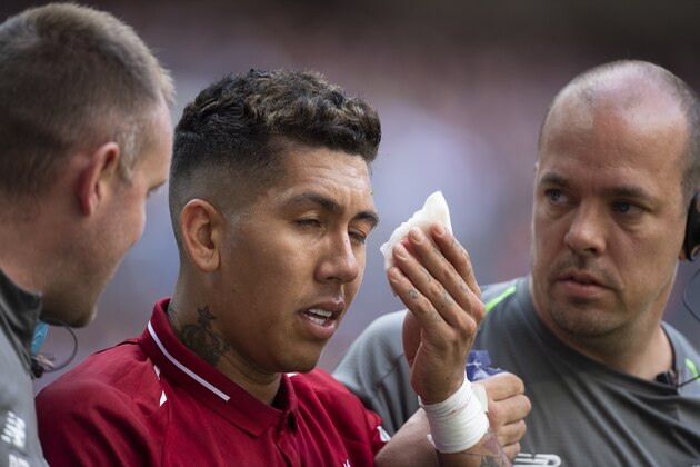 LONDON, ENGLAND - SEPTEMBER 15: Roberto Firmino is helped off the pitch by Liverpool FC medical staff after receiving a finger in the eye from Jan Vertonghen of Tottenham Hotspur during the Premier League match between Tottenham Hotspur and Liverpool FC at Wembley Stadium on September 15, 2018 in London, United Kingdom. (Photo by Visionhaus/Getty Images)