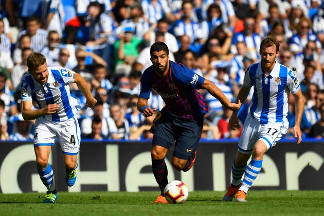 Barcelona's Uruguayan forward Luis Suarez (C) vies with Real Sociedad's Spanish midfielder Asier Illarramendi (L) and Real Sociedad's Spanish midfielder David Zurutuza during the Spanish league football match between Real Sociedad and FC Barcelona at the Anoeta stadium in San Sebastian on September 15, 2018. (Photo by GABRIEL BOUYS / AFP)        (Photo credit should read GABRIEL BOUYS/AFP/Getty Images)