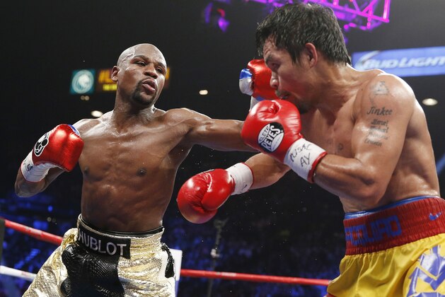 Floyd Mayweather Jr., left, lands a left against Manny Pacquiao, from the Philippines, during their welterweight title fight on Saturday, May 2, 2015 in Las Vegas. (AP Photo/John Locher)
