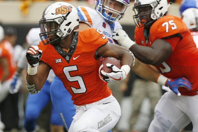 Oklahoma State running back Justice Hill (5) runs past Boise State defensive end Durrant Miles, center, and teammate Marcus Keyes (75) and into the endzone with a touchdown in the first half of an NCAA college football game in Stillwater, Okla., Saturday, Sept. 15, 2018. (AP Photo/Sue Ogrocki)