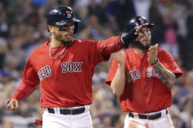 Boston Red Sox's Mookie Betts, left, gestures toward teammate J.D. Martinez after his single which drove in Betts and Blake Swihart, right, during the seventh inning of a baseball game against the Seattle Mariners at Fenway Park, Friday, June 22, 2018, in Boston. (AP Photo/Elise Amendola)
