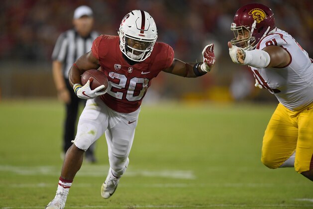 PALO ALTO, CA - SEPTEMBER 08:  Bryce Love #20 of the Stanford Cardinal runs throught the tackle of Brandon Pili #91 of the USC Trojans during the third quarter of an NCAA football game at Stanford Stadium on September 8, 2018 in Palo Alto, California.  (Photo by Thearon W. Henderson/Getty Images)