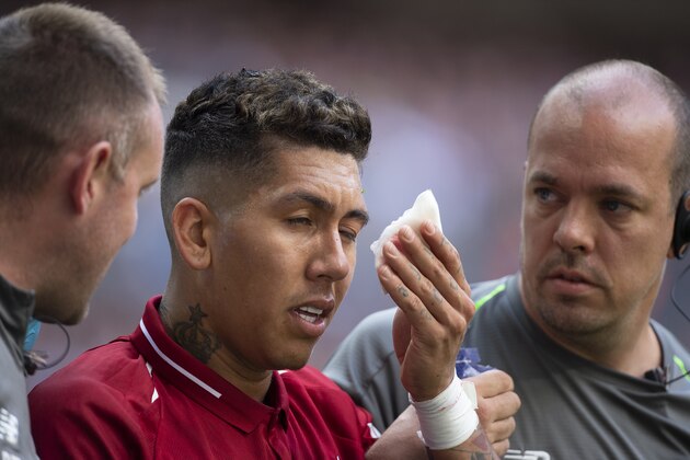 LONDON, ENGLAND - SEPTEMBER 15: Roberto Firmino is helped off the pitch by Liverpool FC medical staff after receiving a finger in the eye from Jan Vertonghen of Tottenham Hotspur during the Premier League match between Tottenham Hotspur and Liverpool FC at Wembley Stadium on September 15, 2018 in London, United Kingdom. (Photo by Visionhaus/Getty Images)