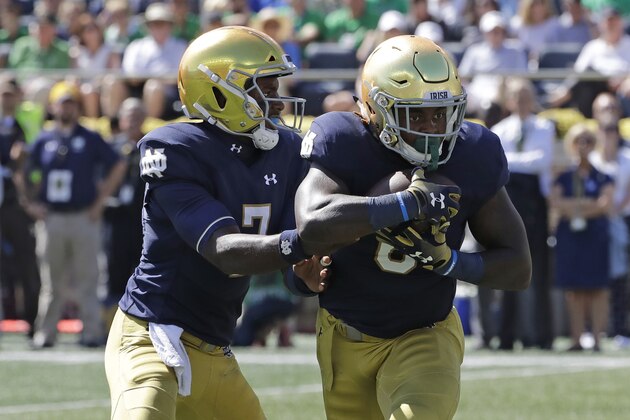 Notre Dame quarterback Brandon Wimbush, left, drops off the ball to running back Tony Jones Jr., during the first half of an NCAA college football game against Vanderbilt in South Bend, Ind., Saturday, Sept. 15, 2018. (AP Photo/Nam Y. Huh)