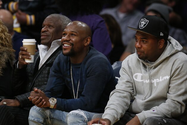 Boxer Floyd Mayweather, center, attends in an NBA basketball game between Los Angeles Lakers and Miami Heat Friday, March 16, 2018, in Los Angeles. (AP Photo/Ringo H.W. Chiu)