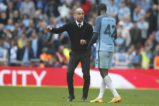 Manchester City manager Pep Guardiola, left, talks to Manchester City's Yaya Toure during the English FA Cup semifinal soccer match between Arsenal and Manchester City at Wembley stadium in London, Sunday, April 23, 2017. (AP Photo/Alastair Grant)
