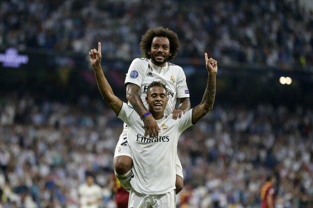 Real forward Mariano Diaz, down, celebrates with defender Marcelo after scoring his side's third goal during a Group G Champions League soccer match between Real Madrid and Roma at the Santiago Bernabeu stadium in Madrid, Spain, Wednesday Sept. 19, 2018. (AP Photo/Manu Fernandez)