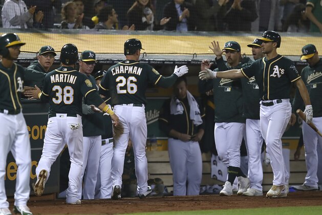 Oakland Athletics' Matt Chapman (26) and Nick Martini (38) are congratulated after scoring against the Los Angeles Angels during the fourth inning of a baseball game Wednesday, Sept. 19, 2018, in Oakland, Calif. (AP Photo/Ben Margot)
