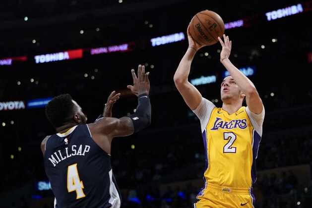 Los Angeles Lakers guard Lonzo Ball, right, attempts a shot ahead of Denver Nuggets forward Paul Millsap during the second half of an NBA basketball game in Los Angeles, Tuesday, March 13, 2018. (AP Photo/Kelvin Kuo)