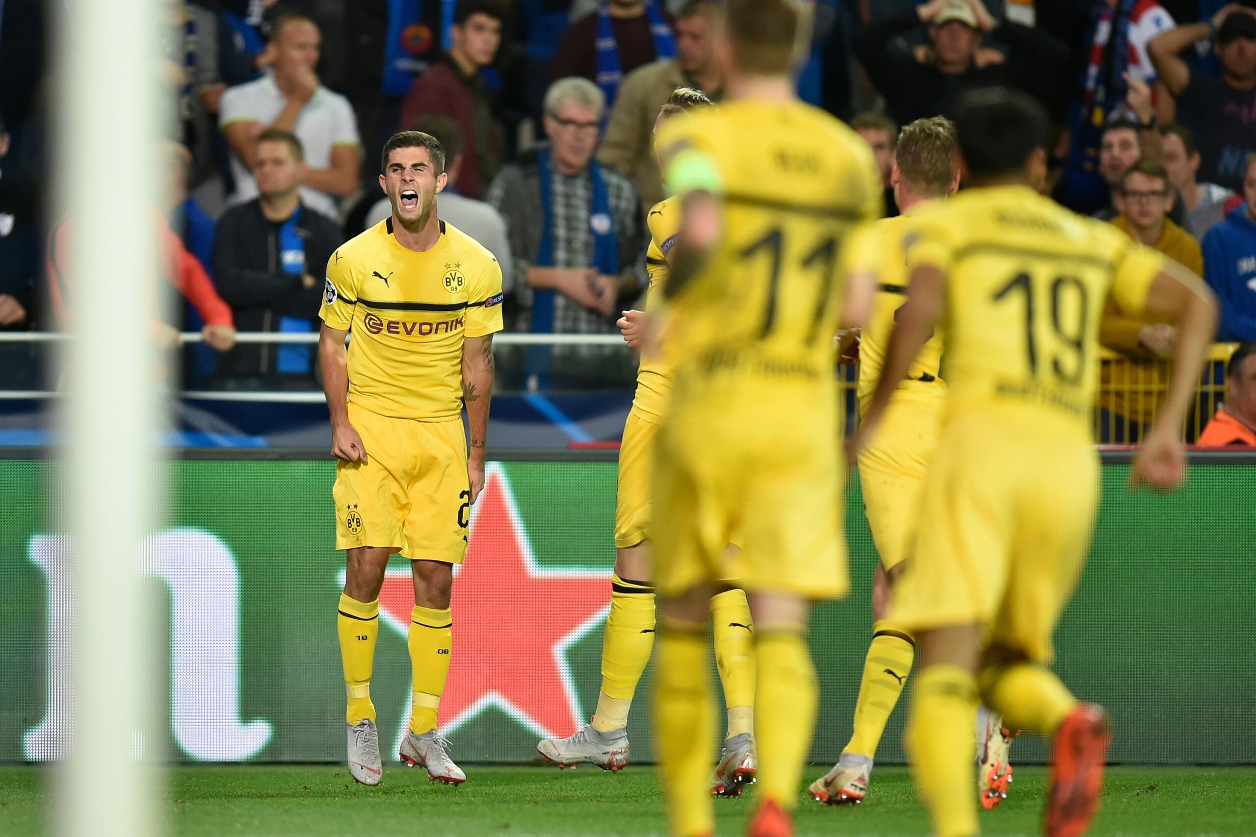 Dortmund's US midfielder Christian Pulisic (L) celebrates after scoring during the UEFA Champions League Group C football match Club Brugge vs Borussia Dortmund  at the Jan Breydel stadium in Bruges on September 18, 2018. (Photo by JOHN THYS / AFP)        (Photo credit should read JOHN THYS/AFP/Getty Images)