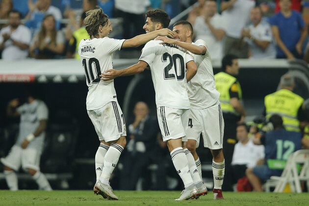 Real midfielder Marco Asensio, center, celebrates with Luka Modric, left, and Dani Ceballos after scoring his side's first goal during a La Liga soccer match between Real Madrid and Espanyol at the Santiago Bernabeu stadium in Madrid, Spain, Saturday, Sept. 22, 2018. (AP Photo/Paul White)