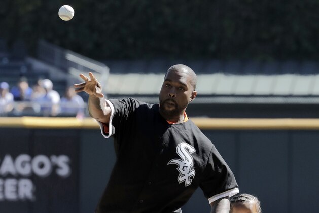 Kanye West, left, throws out a ceremonial first pitch as his son Saint watches before a baseball game between the Chicago Cubs and the Chicago White Sox, Sunday, Sept. 23, 2018, in Chicago. (AP Photo/Nam Y. Huh)