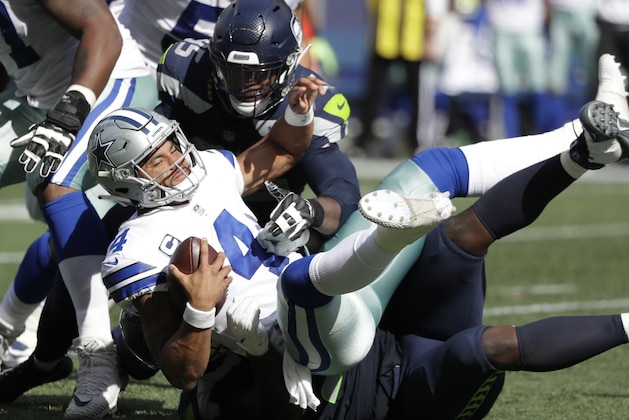 Dallas Cowboys quarterback Dak Prescott (4) is sacked by Seattle Seahawks defensive end Dion Jordan, top, and defensive tackle Jarran Reed, bottom, during the first half of an NFL football game, Sunday, Sept. 23, 2018, in Seattle. (AP Photo/Elaine Thompson)