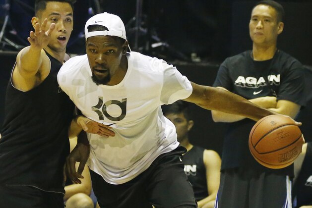 Kevin Durant of the Golden State Warriors and the NBA Finals Most Valuable Player, drives to the basket during an exhibition basketball game with Philippine basketball players at the Smart Araneta Coliseum northeast of Manila, Philippines, Sunday, July 8, 2018. Durant is here for the second time to conduct basketball clinics and to launch his Nike 'KD 11' basketball shoes. (AP Photo/Bullit Marquez)