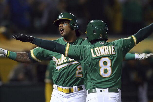 Oakland Athletics' Khris Davis, left, celebrates with Jed Lowrie (8) after hitting a two-run home run off Minnesota Twins' Jose Berrios during the first inning of a baseball game Friday, Sept. 21, 2018, in Oakland, Calif. (AP Photo/Ben Margot)