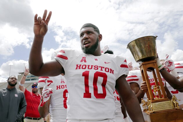 Houston Cougars defensive tackle Ed Oliver does the Cougar Paw with his teammates and the Bayou Bucket trophy after defeating Rice in a NCAA college football game Saturday, Sept. 1, 2018, in Houston. (AP Photo/Michael Wyke)