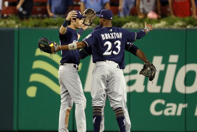 Milwaukee Brewers' Christian Yelich, left, and Keon Broxton (23) celebrate a 12-4 victory over the St. Louis Cardinals in a baseball game Tuesday, Sept. 25, 2018, in St. Louis. (AP Photo/Jeff Roberson)