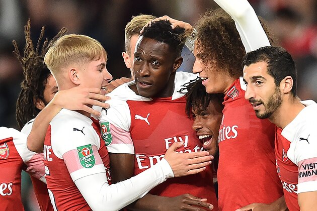 Arsenal's English striker Danny Welbeck (C) is mobbed by teammates after scoring the opening goal during the English League Cup third round football match between Arsenal and Brentford at the Emirates Stadium in London on September 26, 2018. (Photo by Glyn KIRK / AFP) / RESTRICTED TO EDITORIAL USE. No use with unauthorized audio, video, data, fixture lists, club/league logos or 'live' services. Online in-match use limited to 120 images. An additional 40 images may be used in extra time. No video emulation. Social media in-match use limited to 120 images. An additional 40 images may be used in extra time. No use in betting publications, games or single club/league/player publications. /         (Photo credit should read GLYN KIRK/AFP/Getty Images)