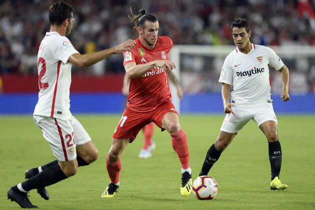 Real Madrid's Welsh forward Gareth Bale (C) vies with Sevilla's Italian midfielder Franco Vazquez (L) and Sevilla's French forward Wissam Ben Yedder during the Spanish league football match Sevilla FC against Real Madrid CF at the Ramon Sanchez Pizjuan stadium in Seville on September 26, 2018. (Photo by CRISTINA QUICLER / AFP)        (Photo credit should read CRISTINA QUICLER/AFP/Getty Images)