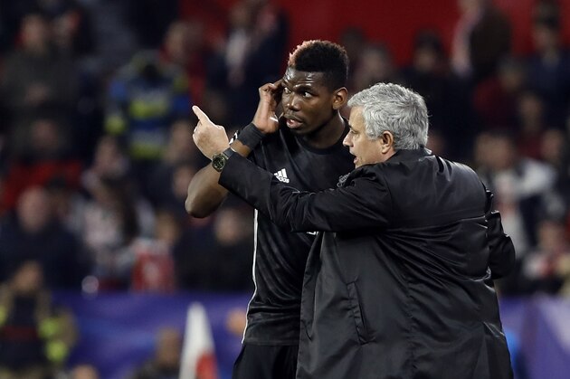 Manchester United manager Jose Mourinho, right, talks to Manchester United's Paul Pogba during the Champions League round of sixteen first leg soccer match between Sevilla FC and Manchester United at the Ramon Sanchez Pizjuan stadium in Seville, Spain, Wednesday, Feb. 21, 2018. (AP Photo/Miguel Morenatti)