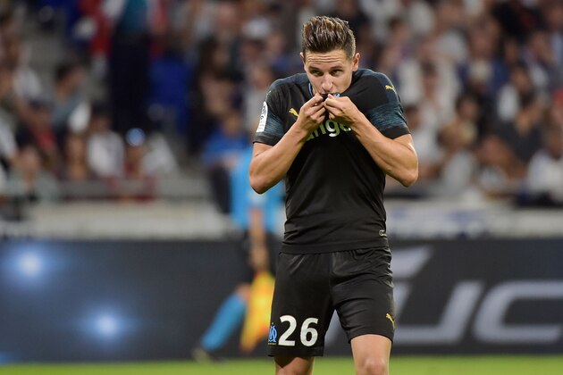 Marseille's French forward Florian Thauvin kisses his club's logo on his jersey as he celebrates after scoring a goal during the French L1 football match between Lyon (OL) and Marseille (OM) on September 23, 2018 at the Groupama stadium in Décines-Charpieu near Lyon. (Photo by ROMAIN LAFABREGUE / AFP)        (Photo credit should read ROMAIN LAFABREGUE/AFP/Getty Images)