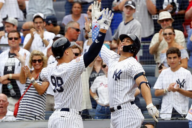 NEW YORK, NY - JULY 04:  Aaron Judge #99 and Giancarlo Stanton #27 of the New York Yankees celebrate a home run hit by Judge in an interleague MLB baseball game against the Atlanta Braves on July 4, 2018 at Yankee Stadium in the Bronx borough of New York City. Yankees won 6-2. Both teams wore clothing and accessories to honor America during the Independence Day weekend games.  (Photo by Paul Bereswill/Getty Images)