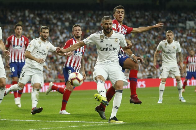 Real Madrid's Karim Benzema, front, vies for the ball with Atletico Madrid's Rodrigo Hernandez during a Spanish La Liga soccer match between Real Madrid and Atletico Madrid at the Santiago Bernabeu stadium in Madrid, Spain, Saturday, Sept. 29, 2018. (AP Photo/Paul White)