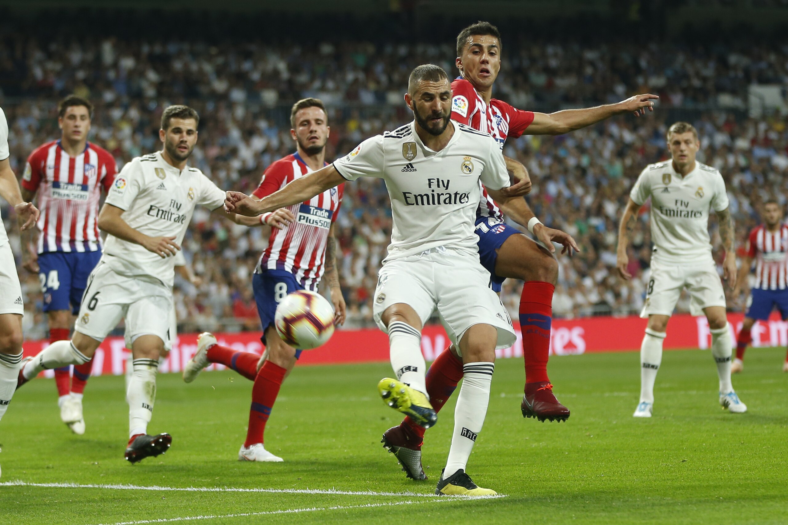 Real Madrid's Karim Benzema, front, vies for the ball with Atletico Madrid's Rodrigo Hernandez during a Spanish La Liga soccer match between Real Madrid and Atletico Madrid at the Santiago Bernabeu stadium in Madrid, Spain, Saturday, Sept. 29, 2018. (AP Photo/Paul White)